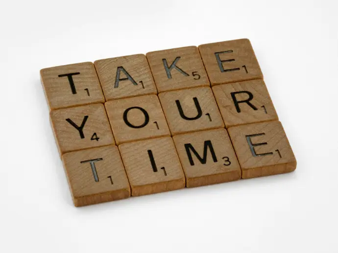 Wooden scrabble letters show the words 'take your time'